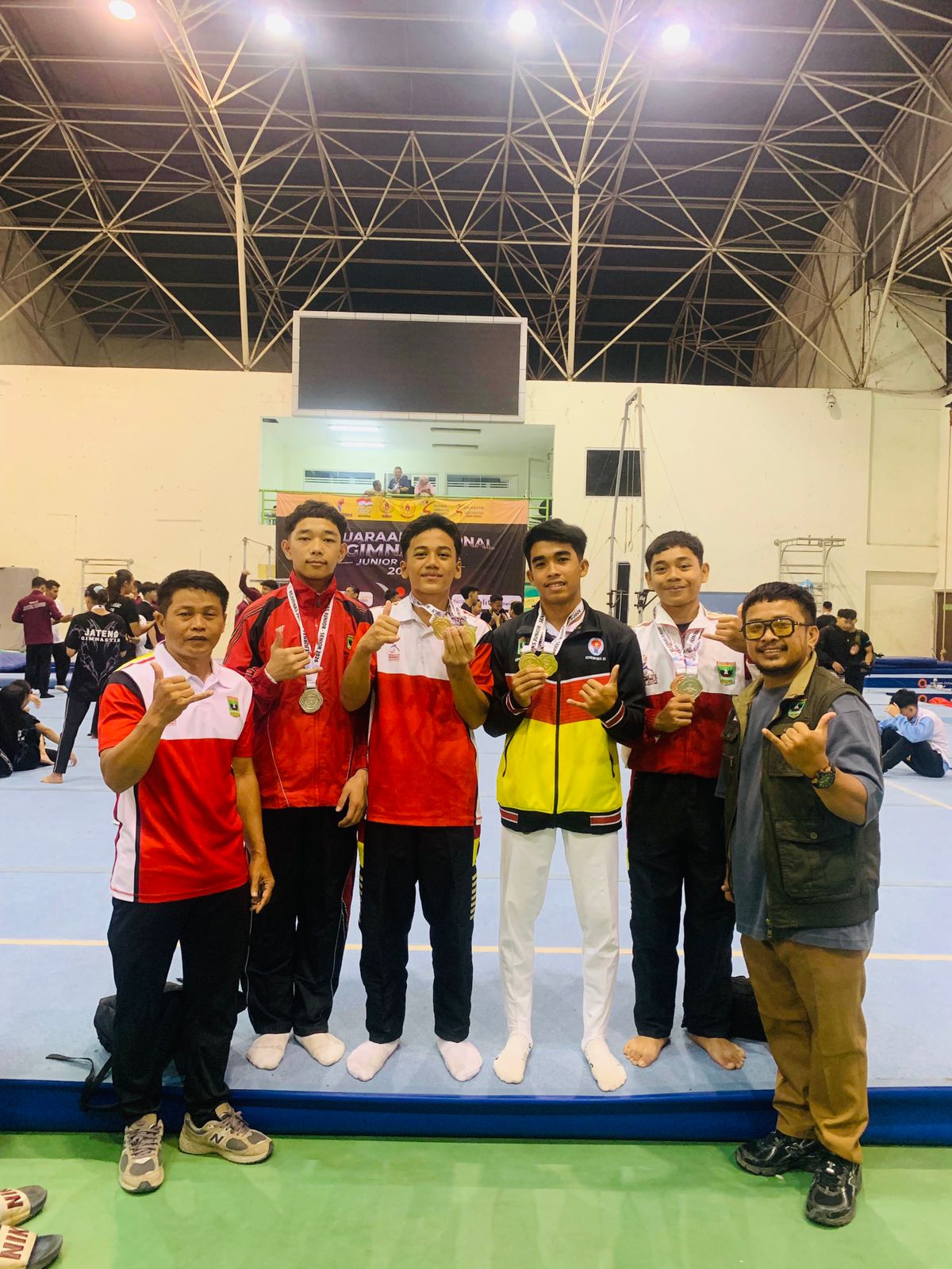 Pelatih Sustrisno (kiri), Binpres KONI Sumbar dan Bimpres Gymnastic SumbarTomy Rhomin Dharu, S.Pd mengapit atlet Sumbar yang meraih medali. (Foto ist)